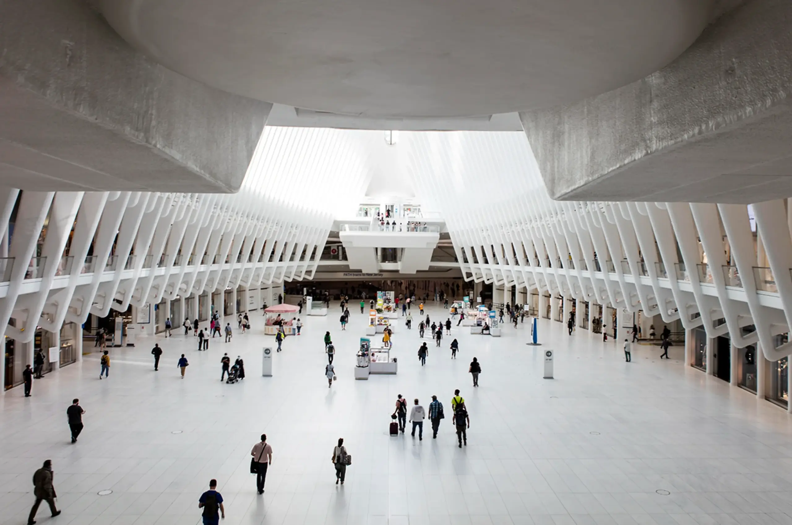 Personen bewegen sich durch eine große, helle öffentliche Halle.